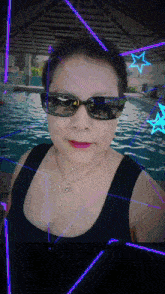a woman wearing sunglasses and a black tank top takes a selfie in front of a pool