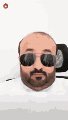 a bald man with a beard and sunglasses on