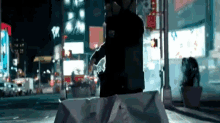 a man is walking down a city street at night