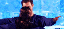 a man and a woman are hugging and the man is wearing a sweatshirt that says amtf .