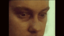 a close up of a person 's face with their eyes closed and looking at the camera .