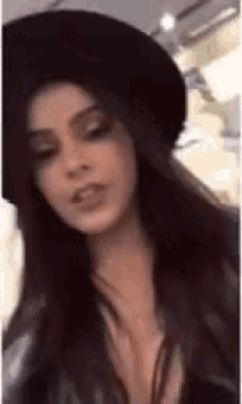 a woman wearing a black hat and a leather jacket is making a funny face .