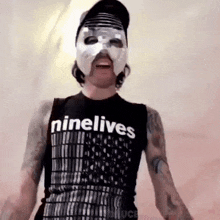 a man wearing a mask and a tank top that says ninelives