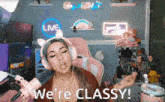 a woman wearing headphones says we 're classy in front of a live sign