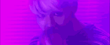 a man is standing in a kitchen with purple lights on the wall .