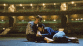 a man and a woman are laying on the floor hugging each other in an auditorium .
