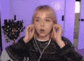a woman wearing earbuds looks surprised and shocked