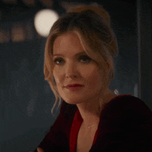 a close up of a woman wearing a red dress and a necklace .