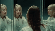 a woman looks at herself in a mirror