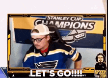 a man is sitting in front of a sign that says stanley cup champions