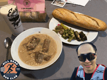 a man wearing sunglasses is standing next to a bowl of soup and a can of easy tiger
