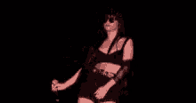 a woman is singing into a microphone in the dark .