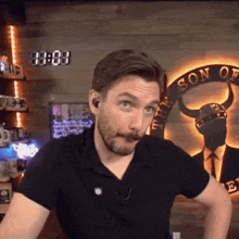 a man with a beard and mustache is standing in front of a sign that says son of the vikings