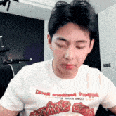 a man wearing a white t-shirt that says ' twice ' on the front
