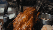 a roasted chicken is on a plate with the letters luw visible