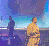 a man singing into a microphone while holding a guitar on a stage