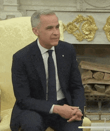 a man in a suit and tie is sitting in a chair