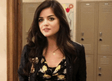 a woman is standing in front of a row of lockers and looking at the camera