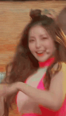 a woman in a pink top is smiling while dancing