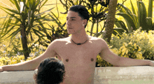 a man without a shirt is leaning on the edge of a hot tub
