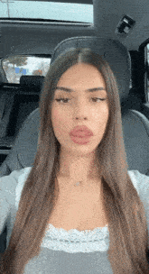 a woman is sitting in the back seat of a car with her eyes closed
