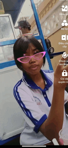 a girl wearing pink glasses and a shirt that says ' a ' on the front
