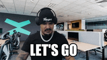 a man wearing headphones and a black shirt says let 's go