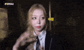 a girl in a suit and tie is standing in a dark room with the word signal on the bottom