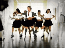 a group of young women are dancing in a hallway