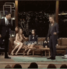 a group of people sitting on a couch with the words dude place on the bottom left