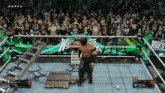 a video game screen shows a wrestler in a wrestling ring with a crowd behind him