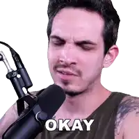 a man in front of a microphone with the word okay on his chest