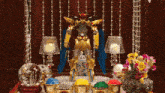 a statue of a robot is surrounded by candles flowers and crystals
