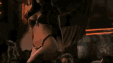 a woman is dancing in a dark room with a fire in the background