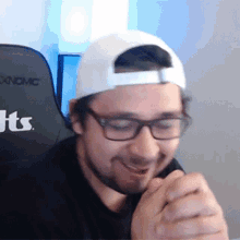 a man wearing glasses and a baseball cap with the letters hts on the back