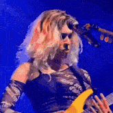 a woman is playing a guitar in front of a microphone .