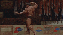 a bodybuilder poses in front of a sign that says blossom on it