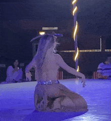 a woman in a tan dress is dancing with a sword