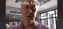 a man says hello tomek in front of a window