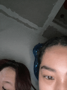 a close up of a woman 's face with a blue item on her head