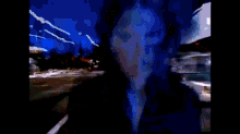 a blurred image of a person driving down a street at night