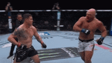 two men are fighting in a boxing ring and one of them has a monster energy logo on his shorts