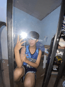 a person taking a selfie in front of a mirror with a jersey that says ' hot 21gh ' on it