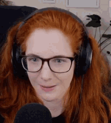 a woman with red hair and glasses wearing headphones and a microphone .