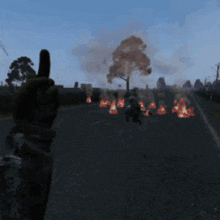a person giving a thumbs up in front of a fire