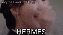 a close up of a woman 's face with the word hermes written on the bottom