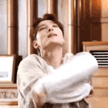 a man is holding a white towel in his hands in a living room .