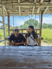 a boy and a girl are sitting on a swing and the girl is wearing a shirt that says portrait