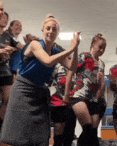 a woman in a blue shirt that says kia is dancing