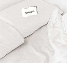a white pillow with a piece of paper on it that says goodnight